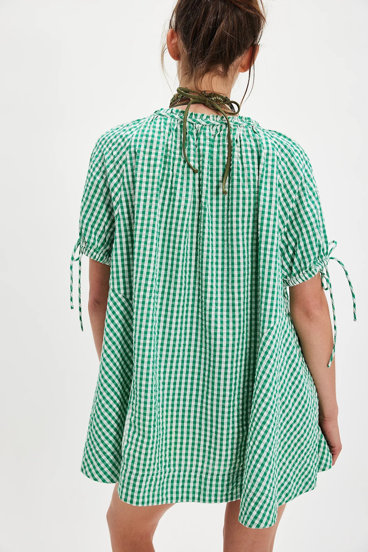 Green checkered dress worn by a person on a white background