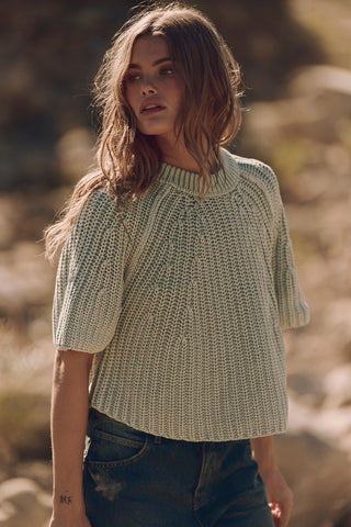 Woman wearing a knitted sweater in a natural setting