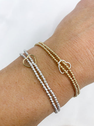 Close-up of a wrist wearing three bracelets on a white background
