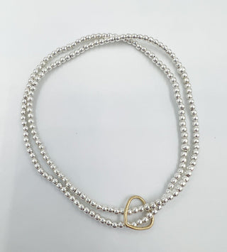 a double layer silver beaded bracelet with a heart charm