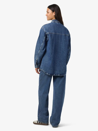 Person wearing a blue denim outfit on a white background