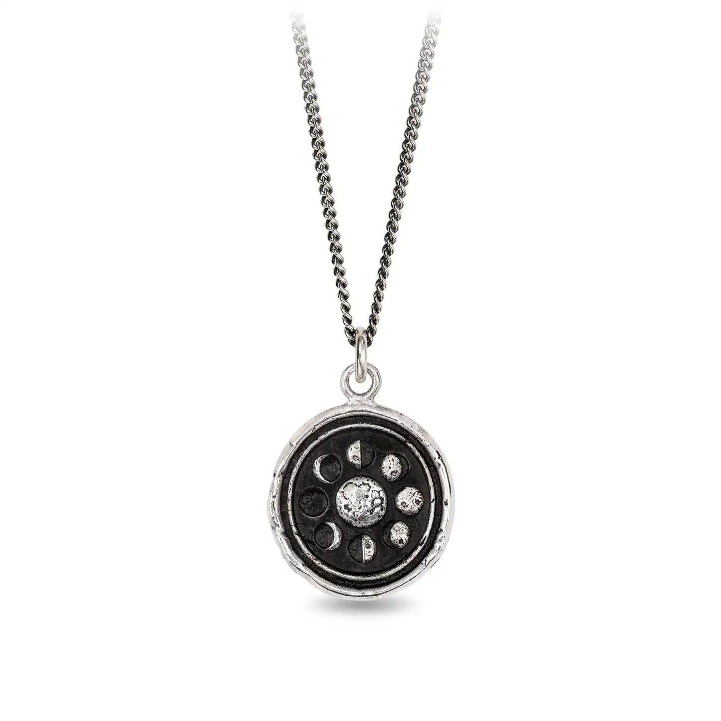 Silver necklace with a circular pendant featuring celestial design on a white background