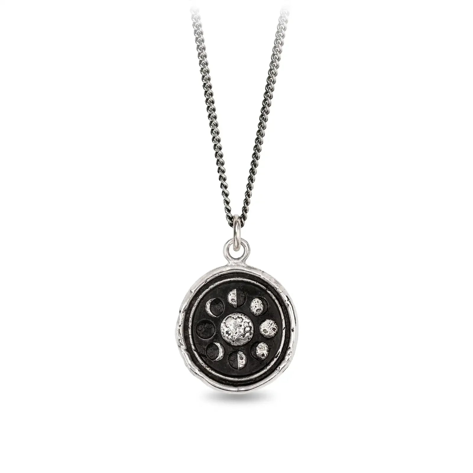 Silver necklace with a circular pendant featuring celestial design on a white background