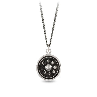Silver necklace with a circular pendant featuring celestial design on a white background