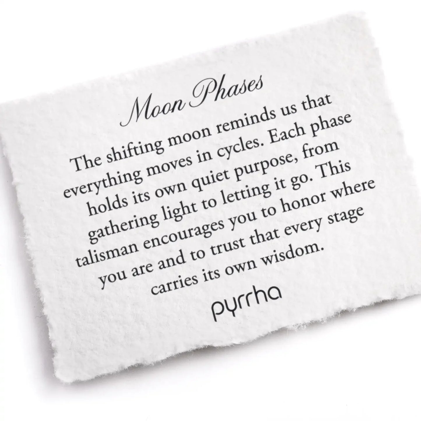 White stone with engraved text about moon phases and pyrrha branding