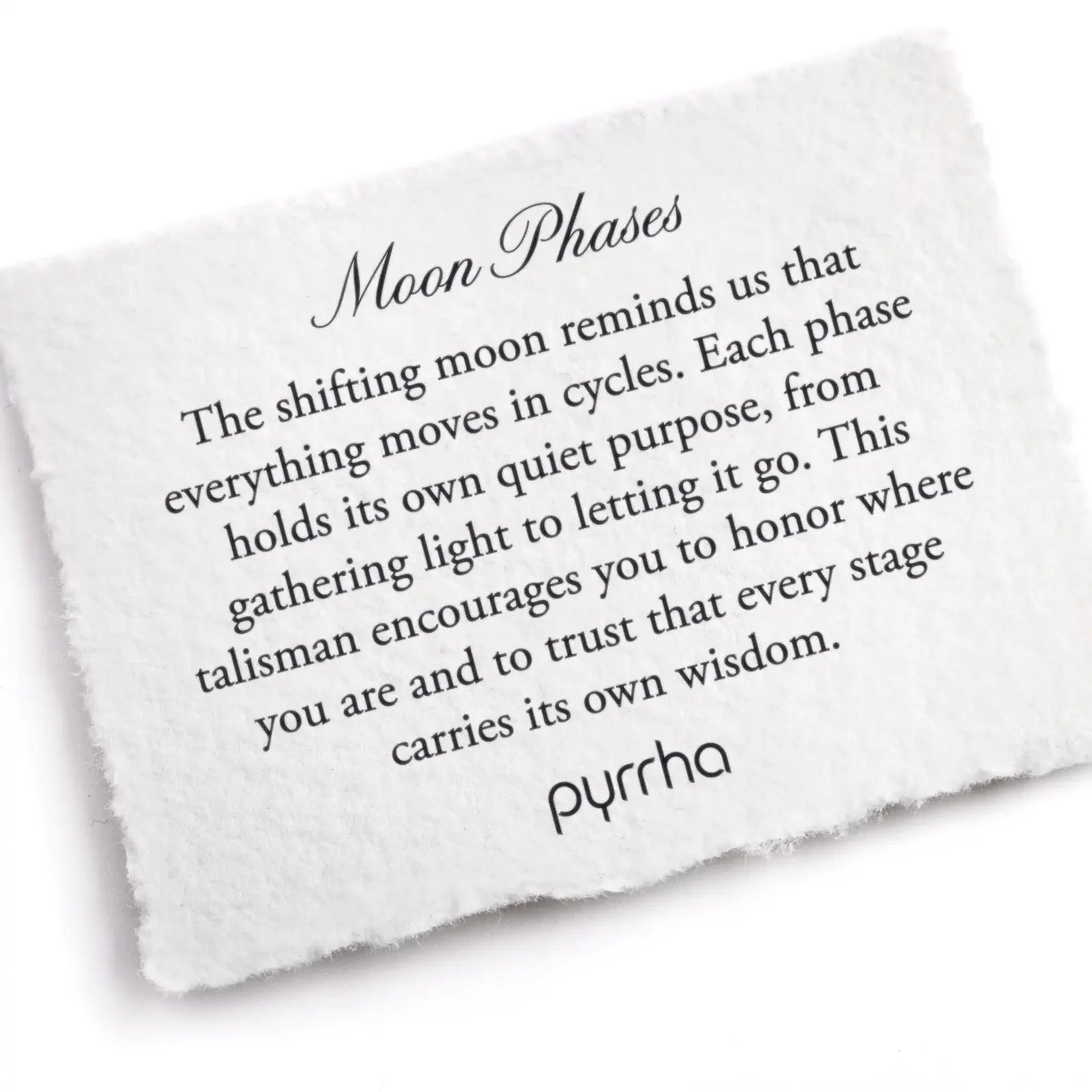 White stone with engraved text about moon phases and pyrrha branding