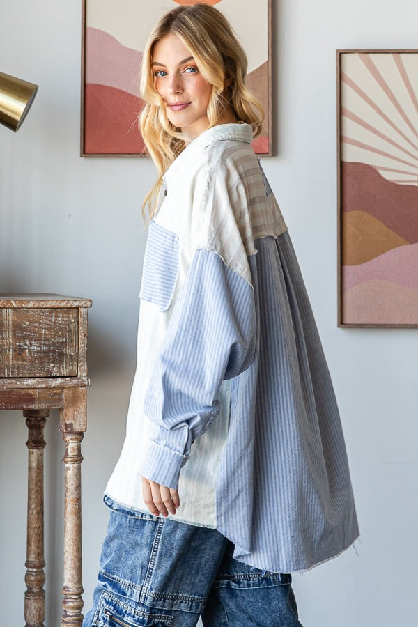 Woman wearing a patterned shirt and jeans in a room with abstract art on the wall.