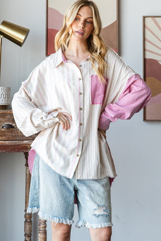Woman wearing a layered outfit with a white shirt, pink cardigan, and denim shorts in a room setting.