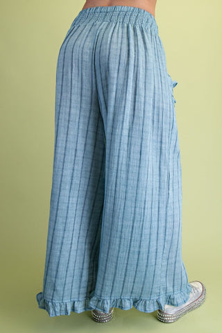 Light blue checkered pants with ruffled bottom on a green background
