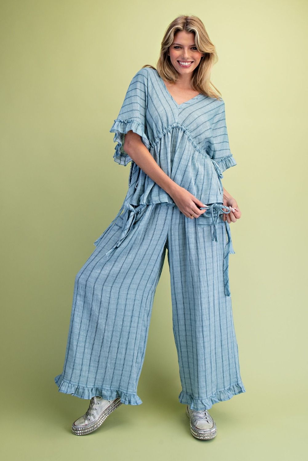 Woman wearing a blue striped outfit on a green background
