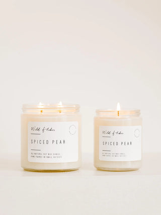 Two lit jar candles labeled Wild of Eden Spiced Pear, shown on a clean white background.