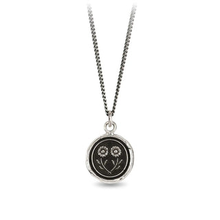 Necklace with a round pendant featuring floral designs on a white background