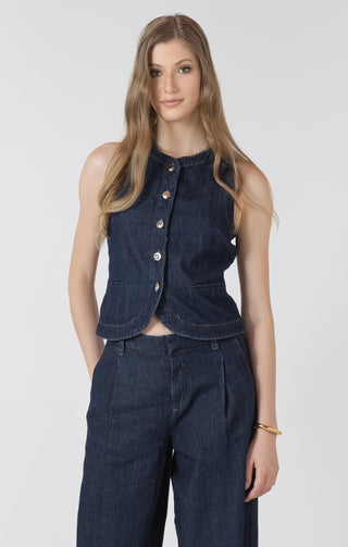 Woman wearing a denim vest and pants on a white background