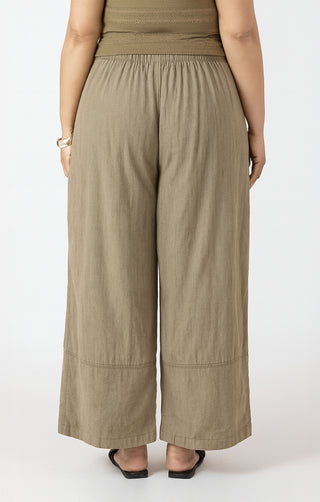 Person wearing beige wide-leg pants on a white background