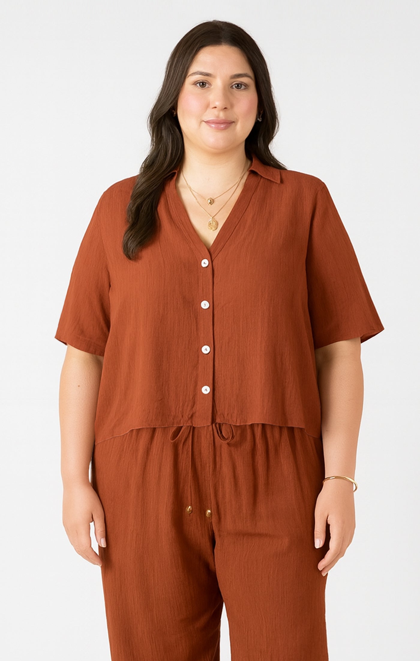 Woman wearing a brown outfit with a matching top and pants on a white background