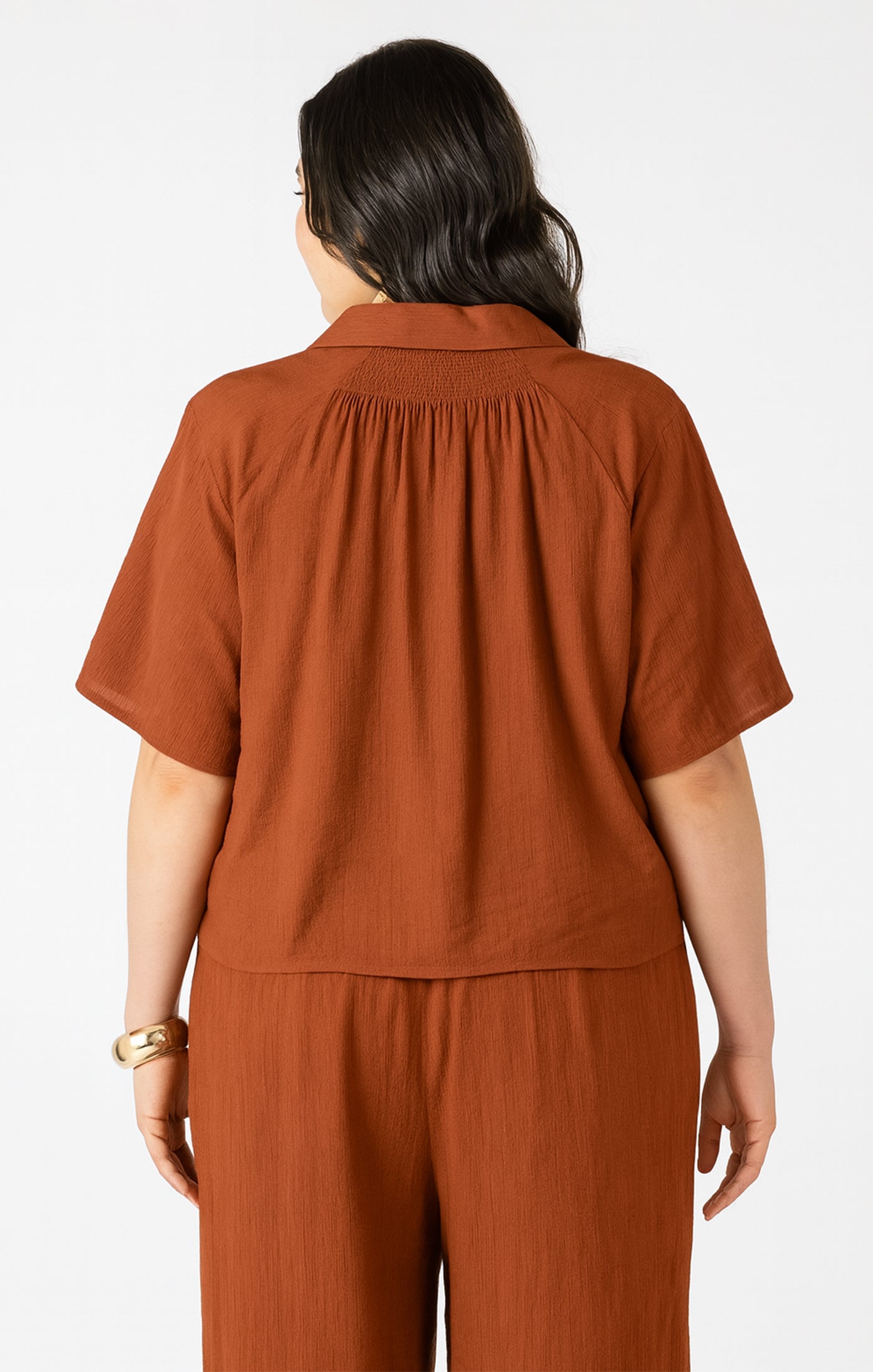 Person wearing a brown outfit on a white background
