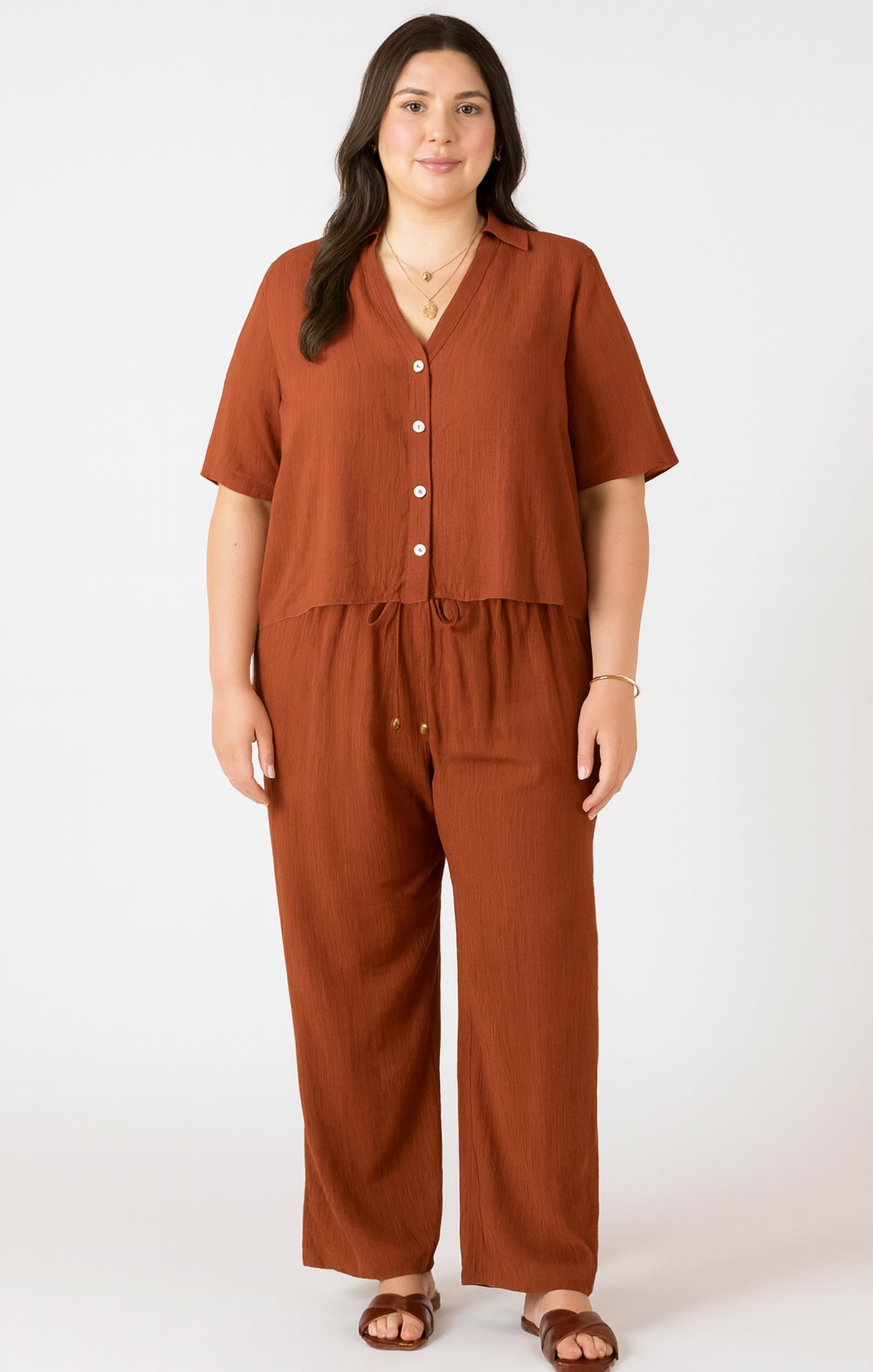 Woman wearing a brown jumpsuit on a white background