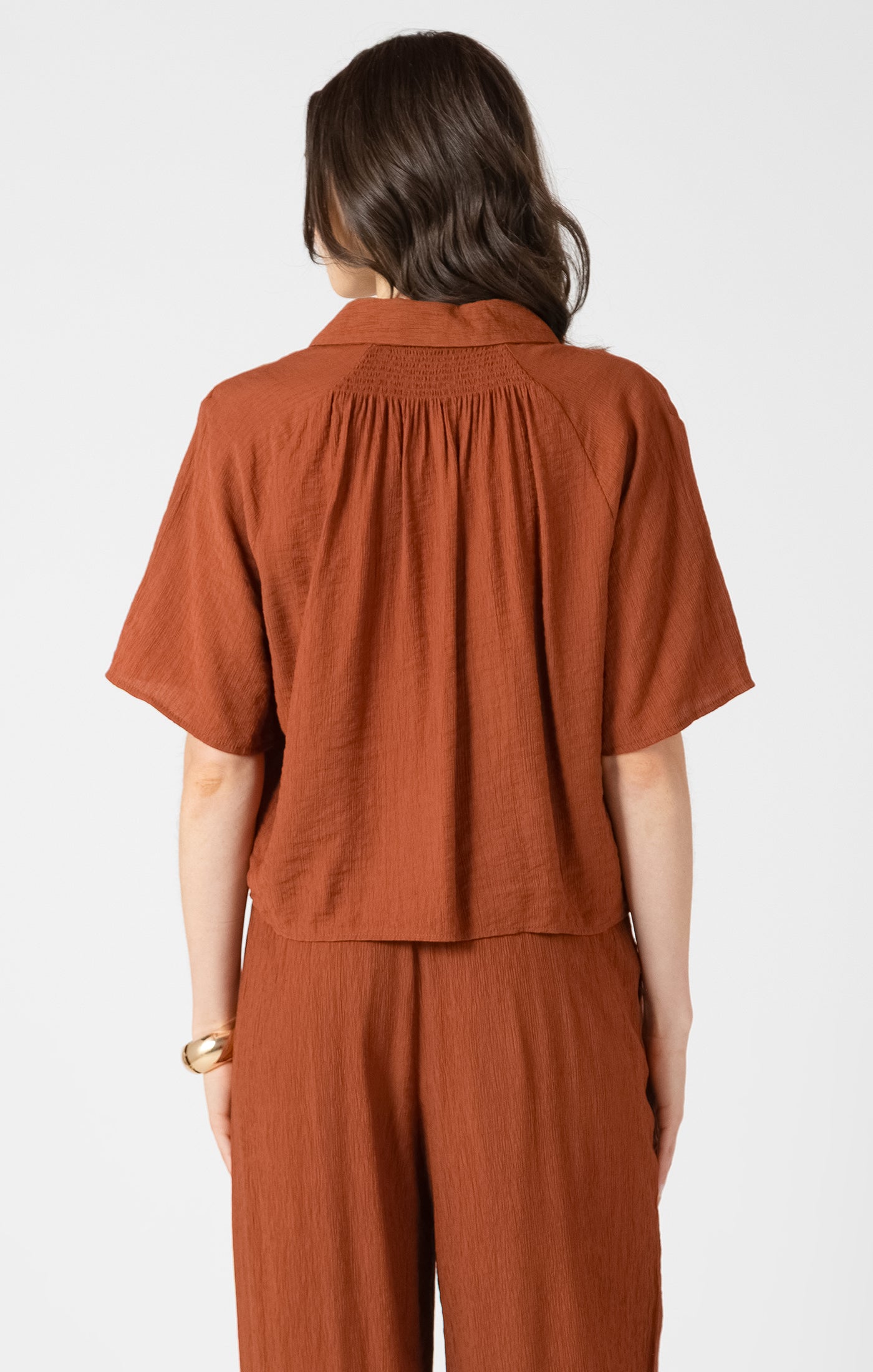 Person wearing a brown outfit on a white background