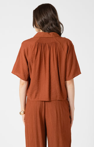 Person wearing a brown outfit on a white background