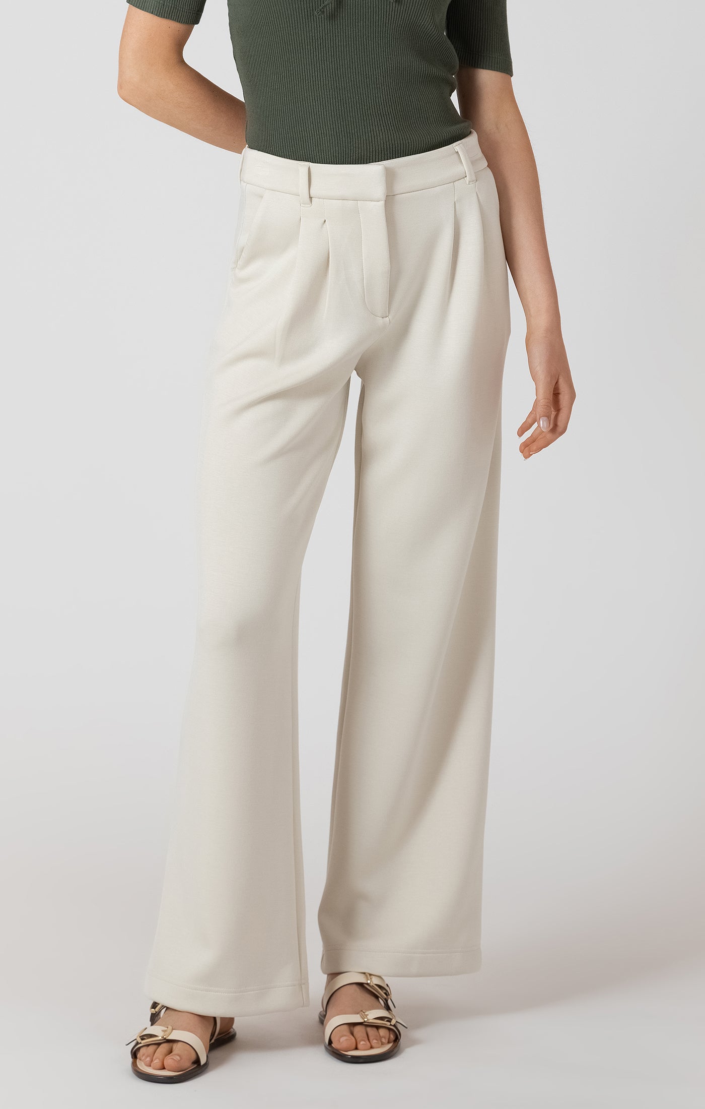 Person wearing white wide-leg pants on a plain background