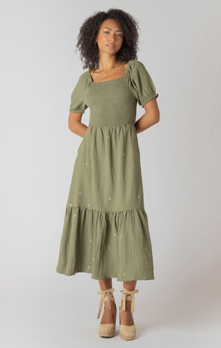 Woman wearing a green dress with puff sleeves against a white background