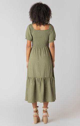 Woman wearing a green dress with puff sleeves on a white background