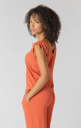 Woman wearing an orange outfit with a plain background