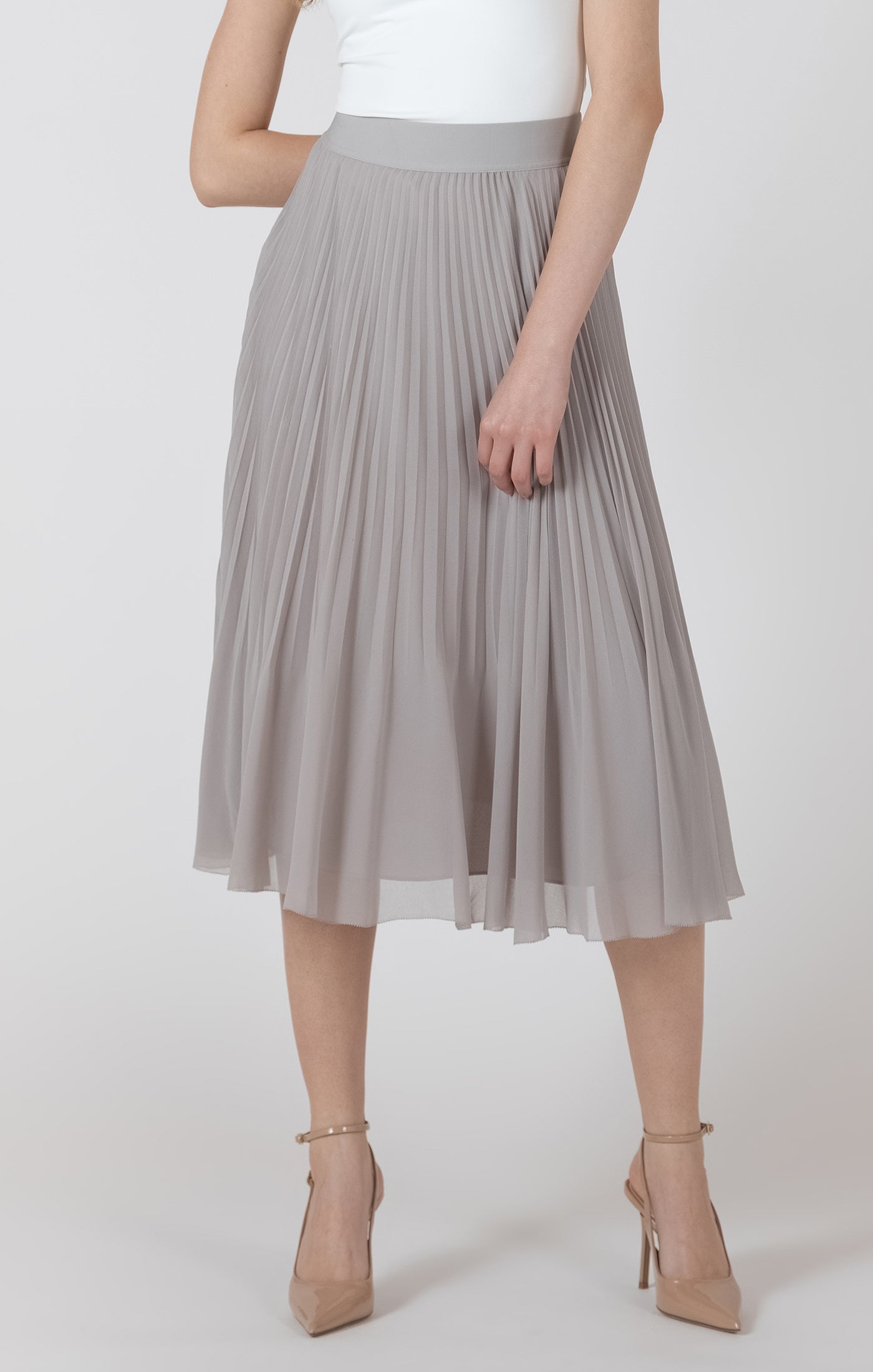 Person wearing a gray pleated skirt on a white background