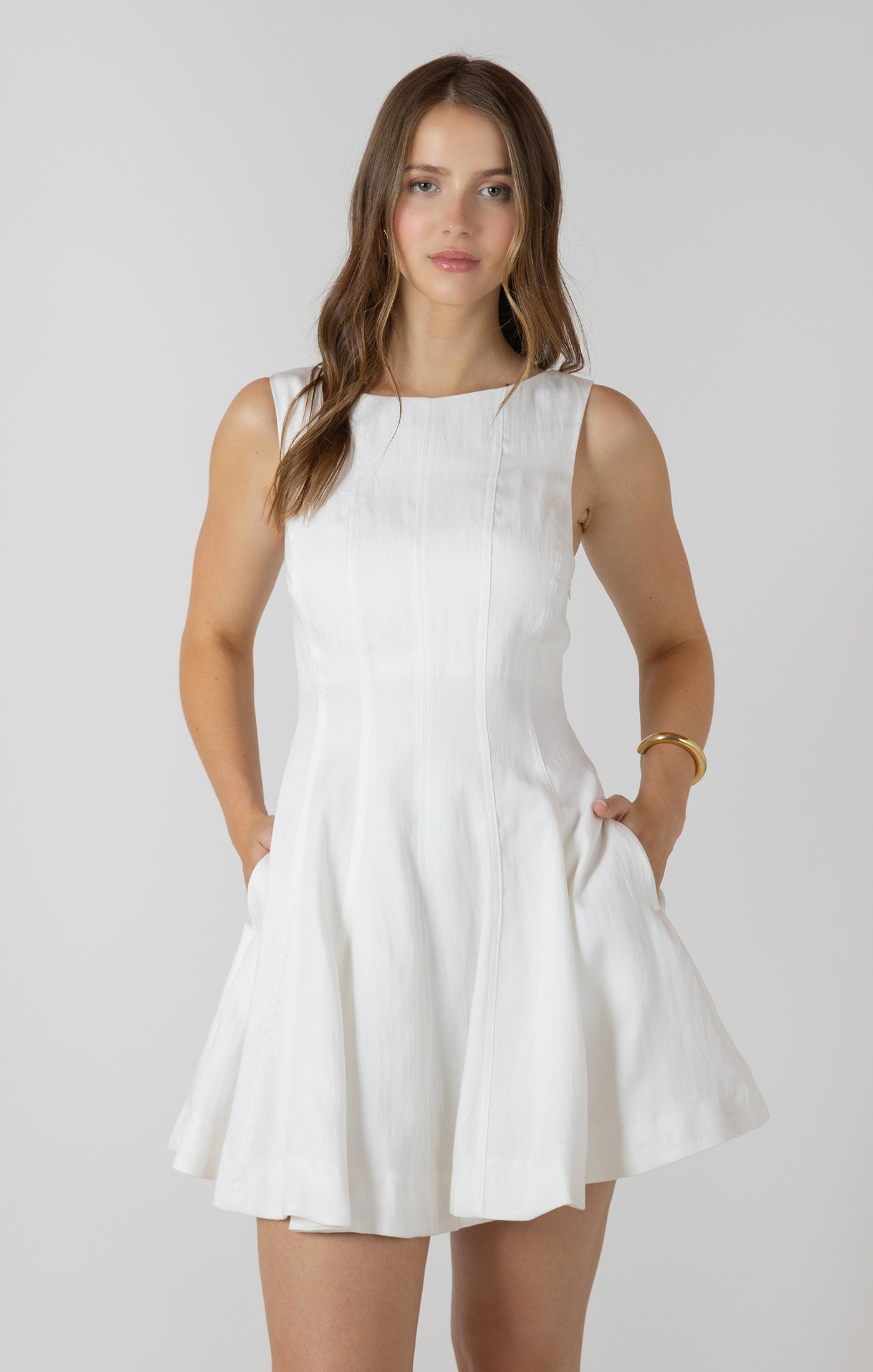 Woman wearing a white dress against a plain background