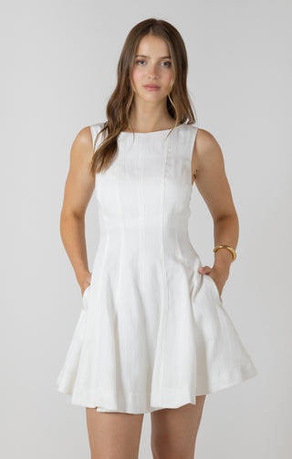 Woman wearing a white dress against a plain background