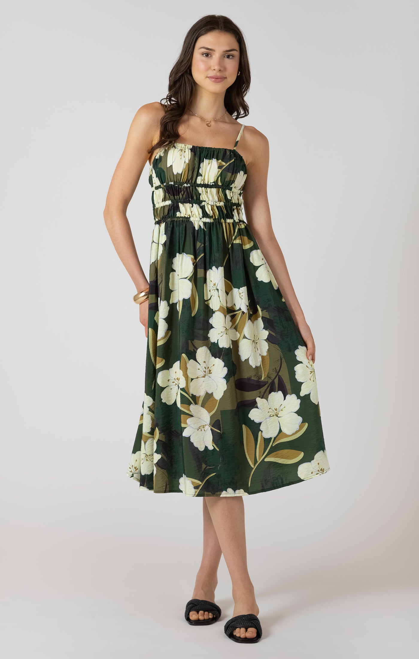 Woman wearing a green floral dress on a white background