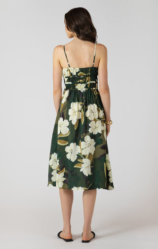 Woman wearing a floral dress with white flowers on a plain background