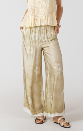 Person wearing a beige top and wide-leg pants on a white background