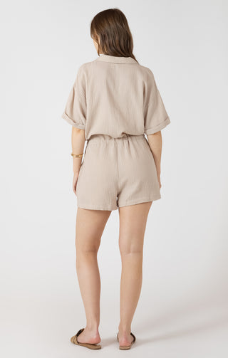Woman wearing a beige romper on a white background