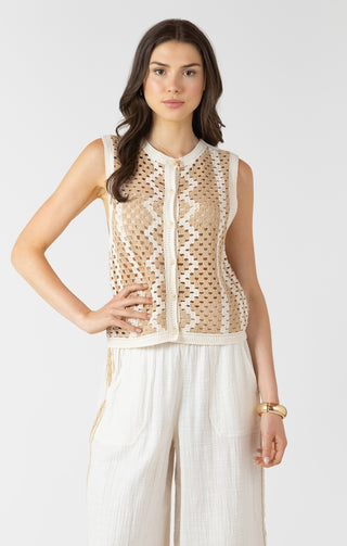 Woman wearing a beige lace top and white pants on a white background