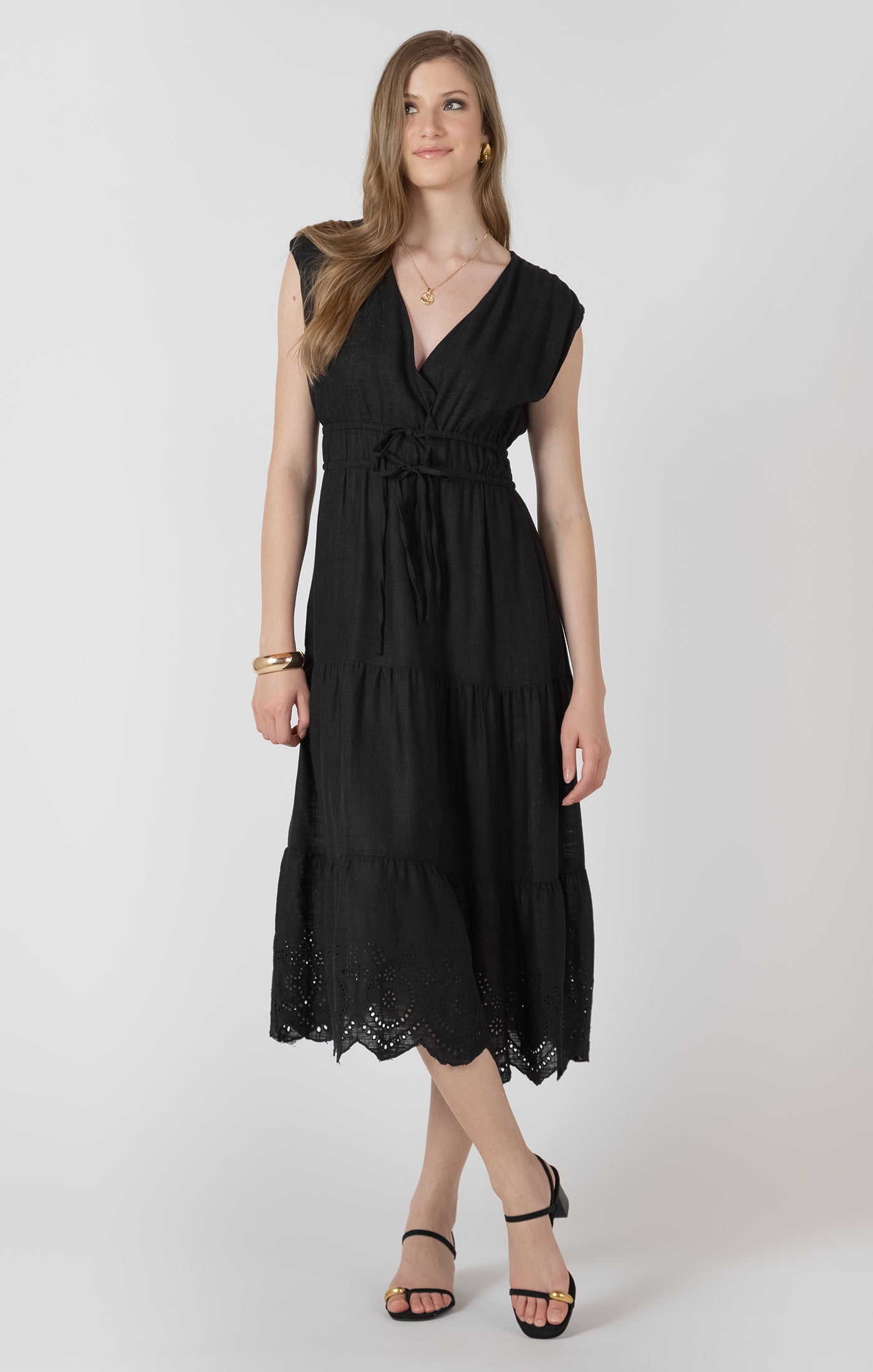 Woman wearing a black dress with lace details on a white background