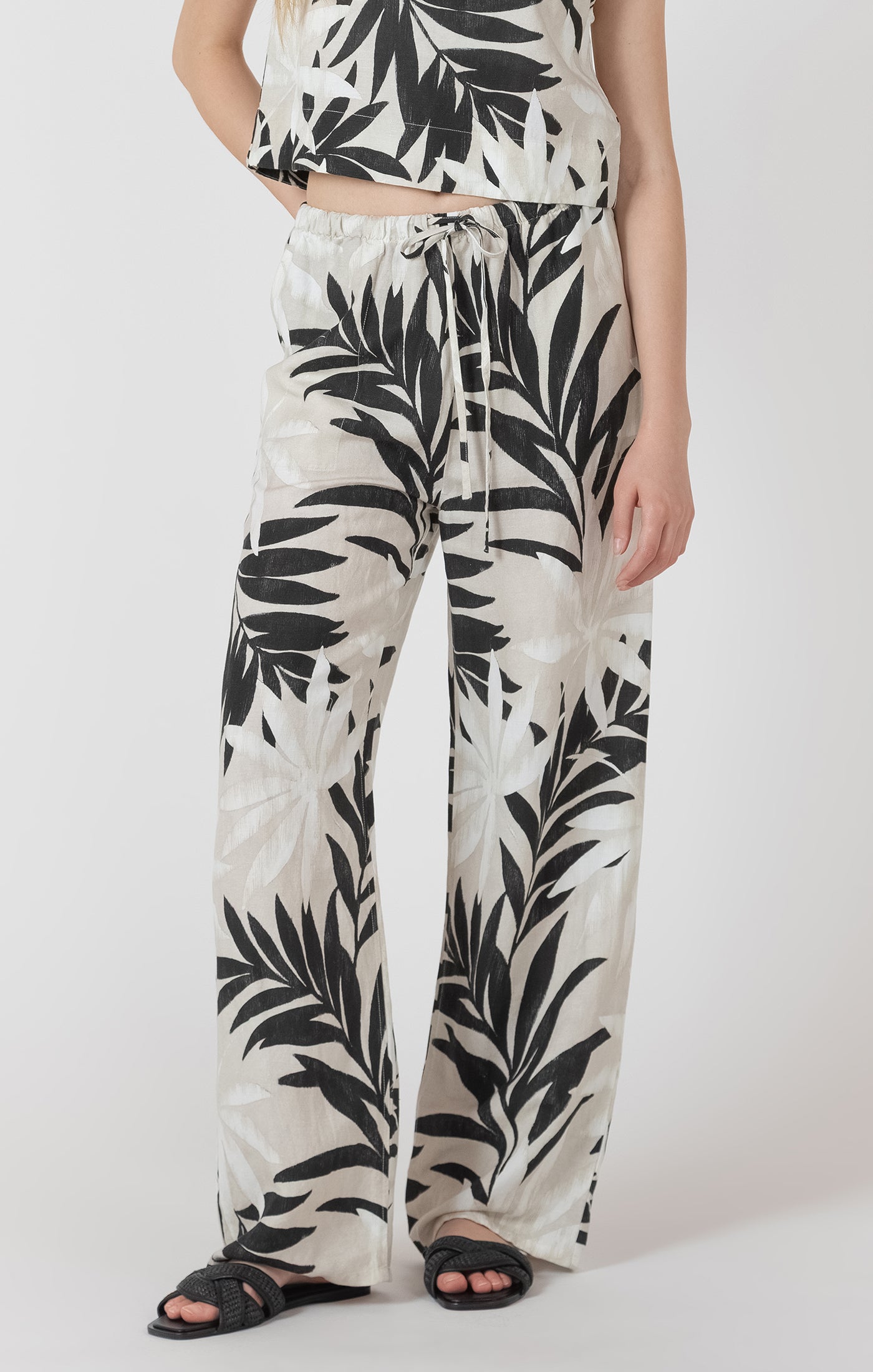 Person wearing a black and white leaf-patterned outfit on a white background