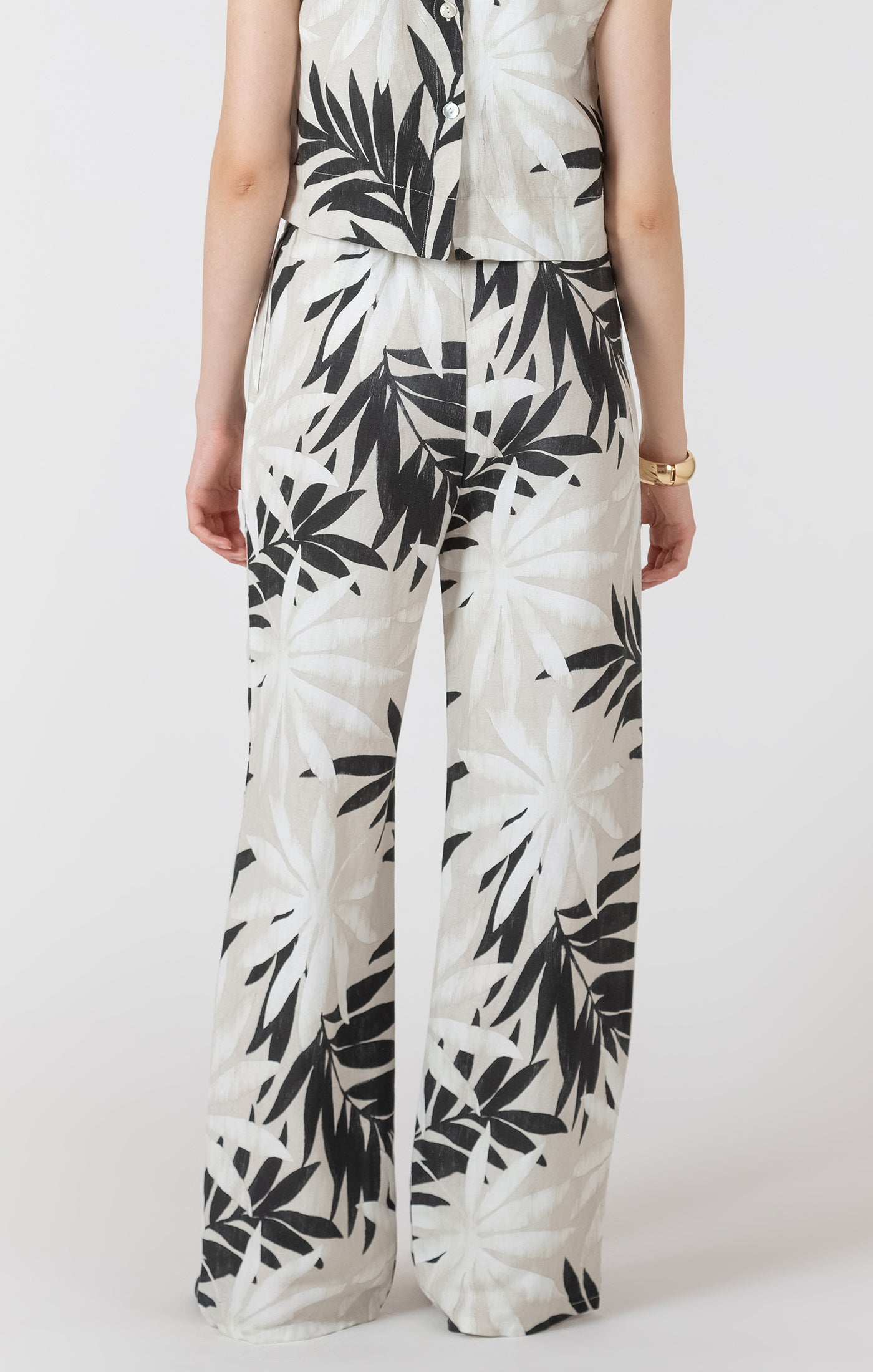 Person wearing a white outfit with black leaf pattern on a white background
