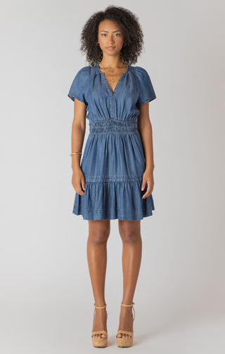 Woman wearing a blue denim dress on a white background