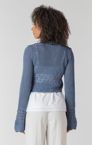 Woman wearing a blue knitted cardigan on a white background