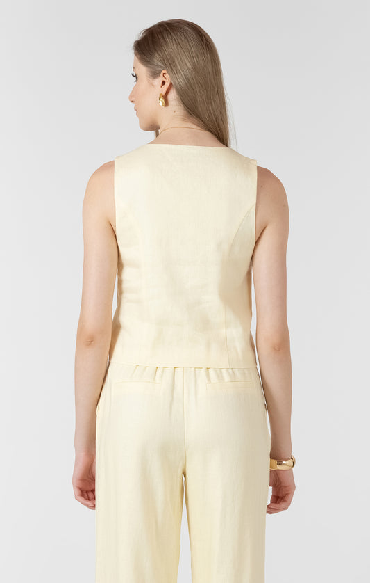 Woman wearing a light yellow top and pants on a white background