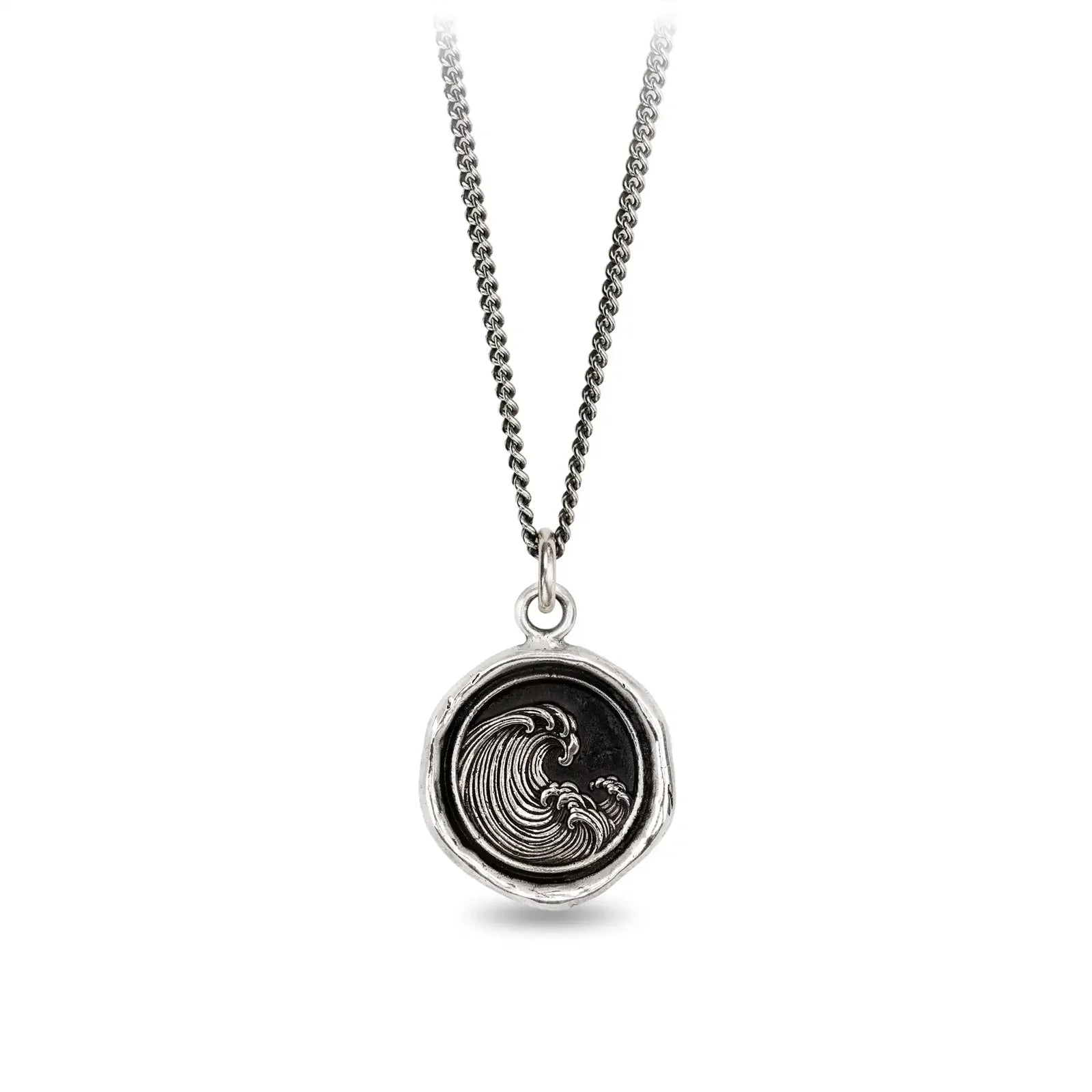 Silver necklace with a round pendant featuring a wave design on a white background