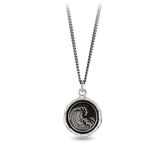 Silver necklace with a round pendant featuring a wave design on a white background