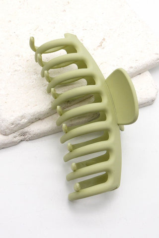 a plastic claw clip in a green colour