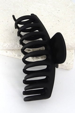 Black hair clip on a textured white background