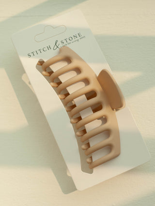 a plastic claw clip in a cream colour