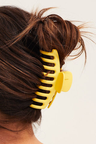 a plastic claw clip in a yellow colour