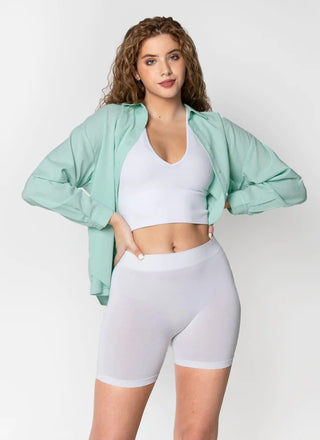 A woman wearing bamboo seamless shorts and a white tank top. 