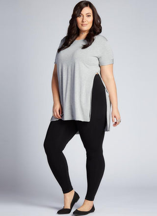 A model wearing black bamboo curvy full-length leggings under a gray t-shirt.