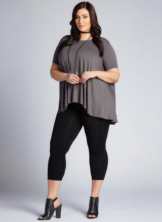 A model wearing black 3/4 high waisted leggings and a matching top.